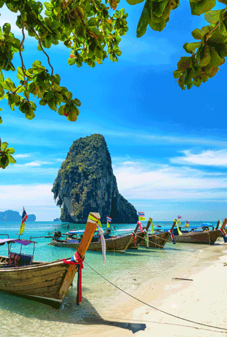 Long-tail boats on a pristine beach in Thailand