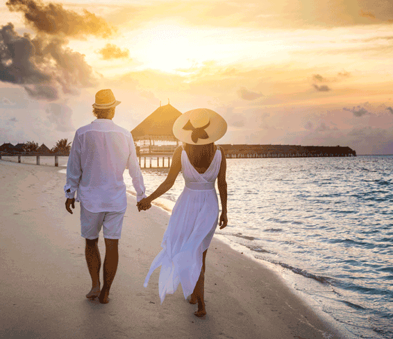Couple walk a tropical beach holding hands