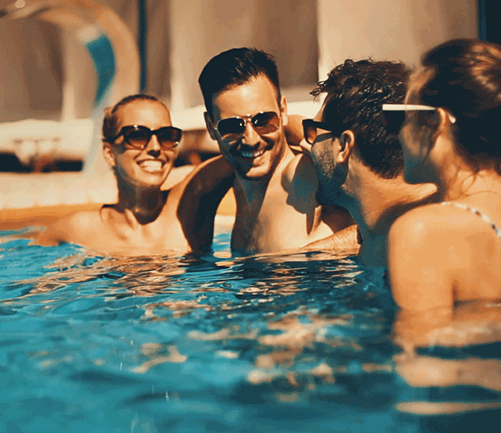 Smiling hotel guests in outdoor swimming pool